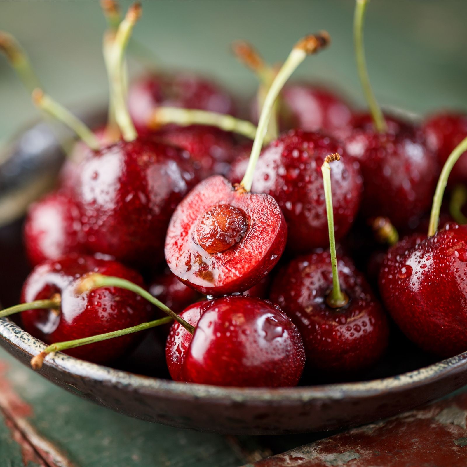 A bowl of cherries with a cherry seed ready for propagation