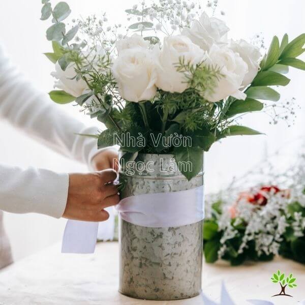 A creative, asymmetric rose arrangement in a tall vase