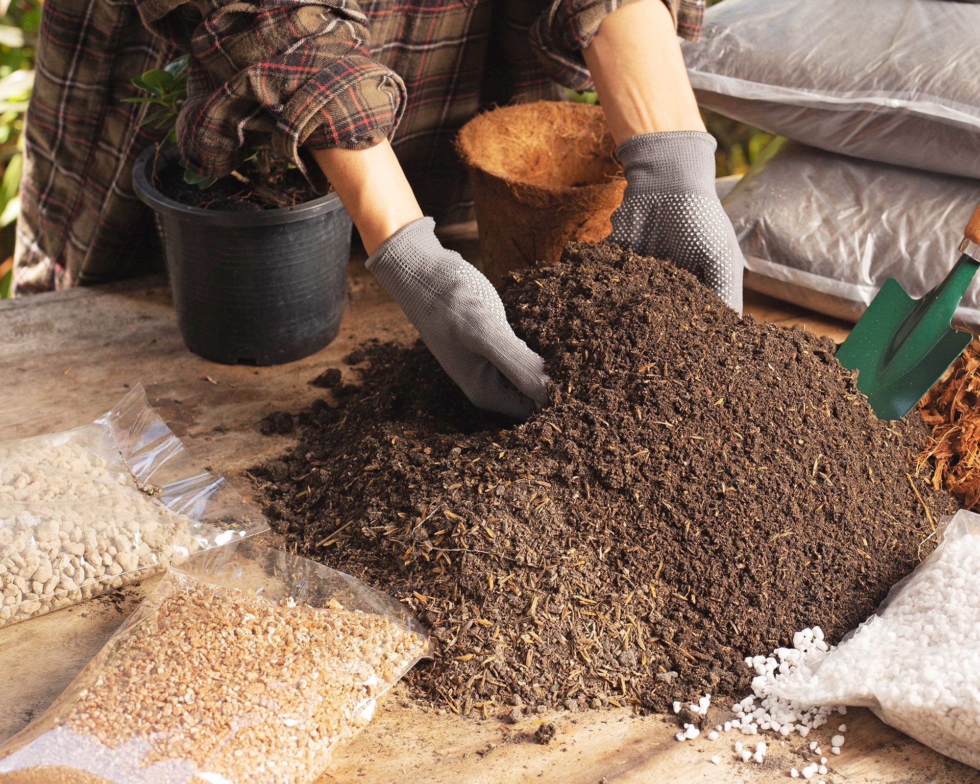 Hands mixing ingredients for a custom potting mix, ideal for growing tomatoes in containers or raised beds