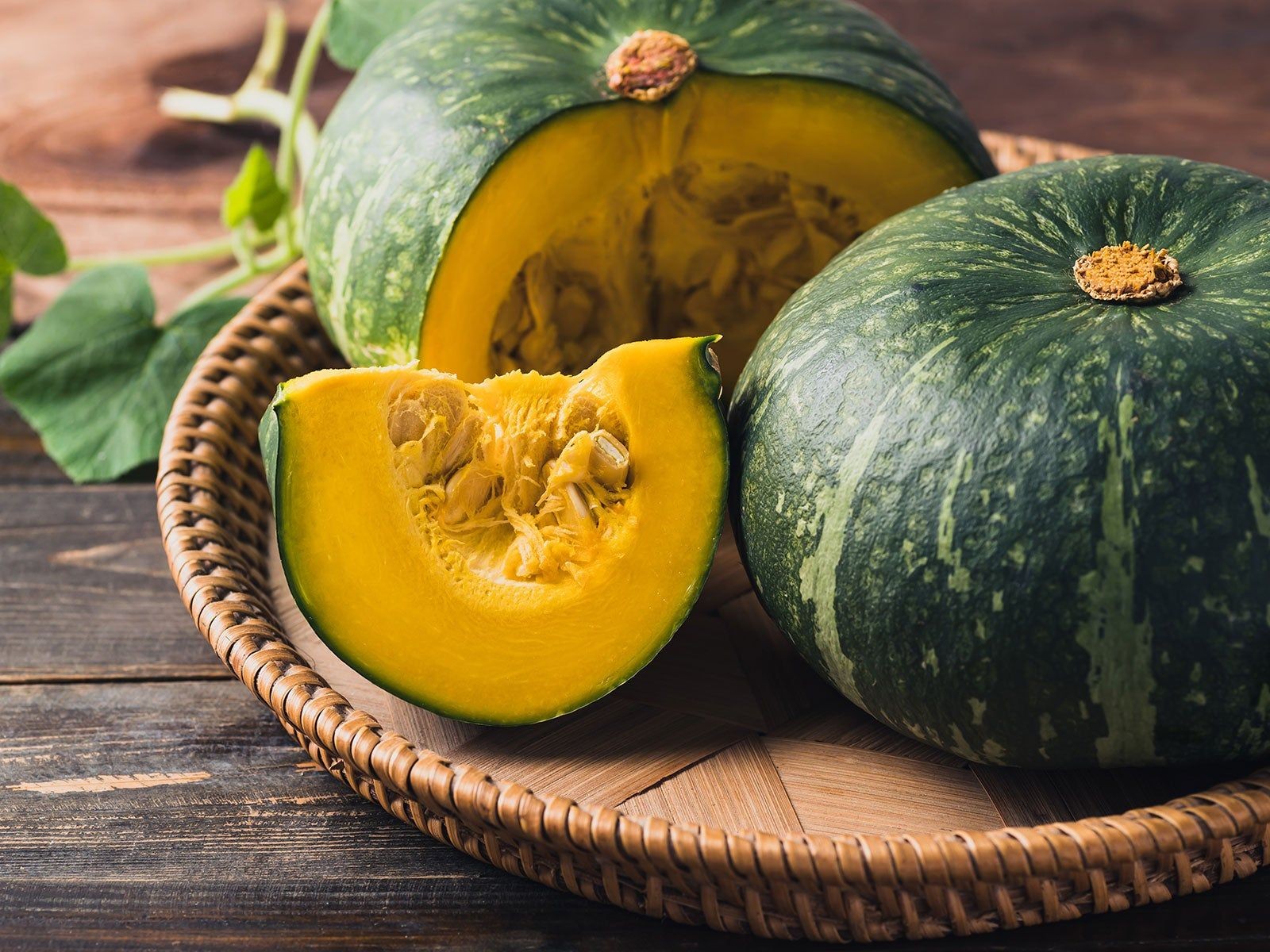 Harvested Kabocha squash with textured green skin and sliced view - also known as Japanese squash