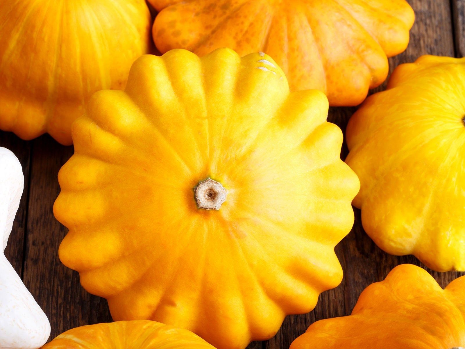 Pile of vibrant yellow Patty Pan summer squash with fluted edges