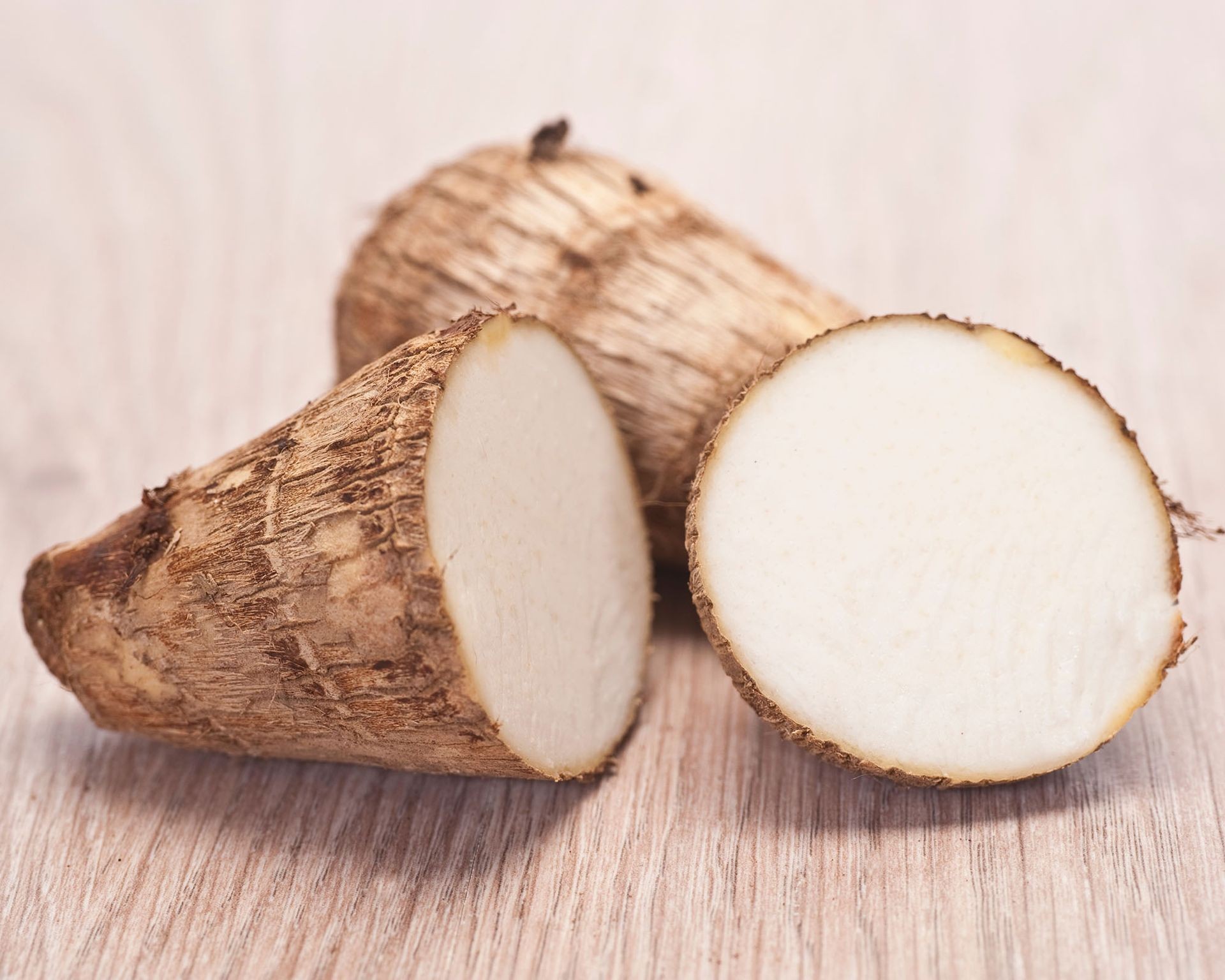 Raw taro root corm, showing its textured skin and potential as a starchy staple